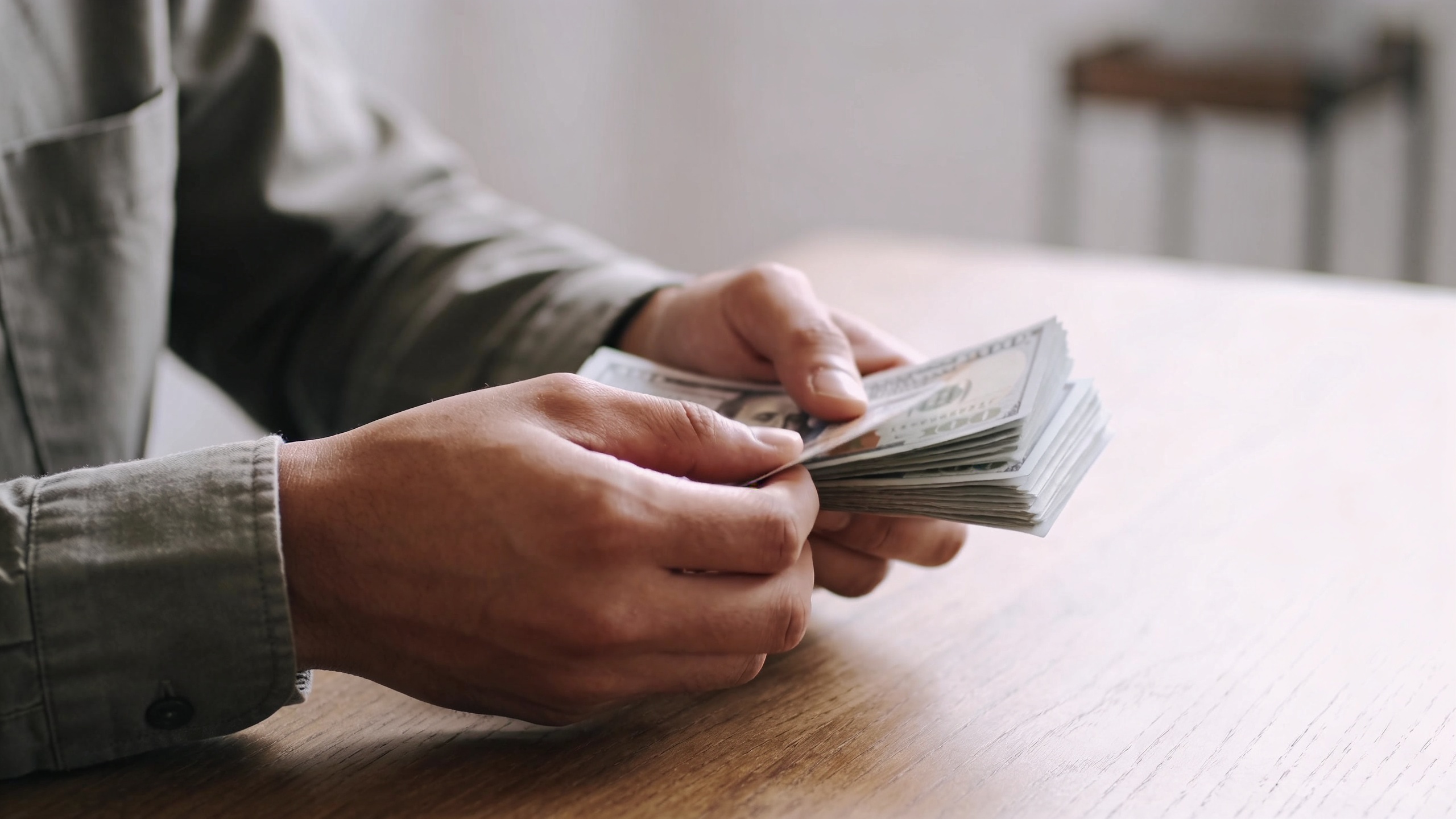 locataire assis a une table comptant des billets