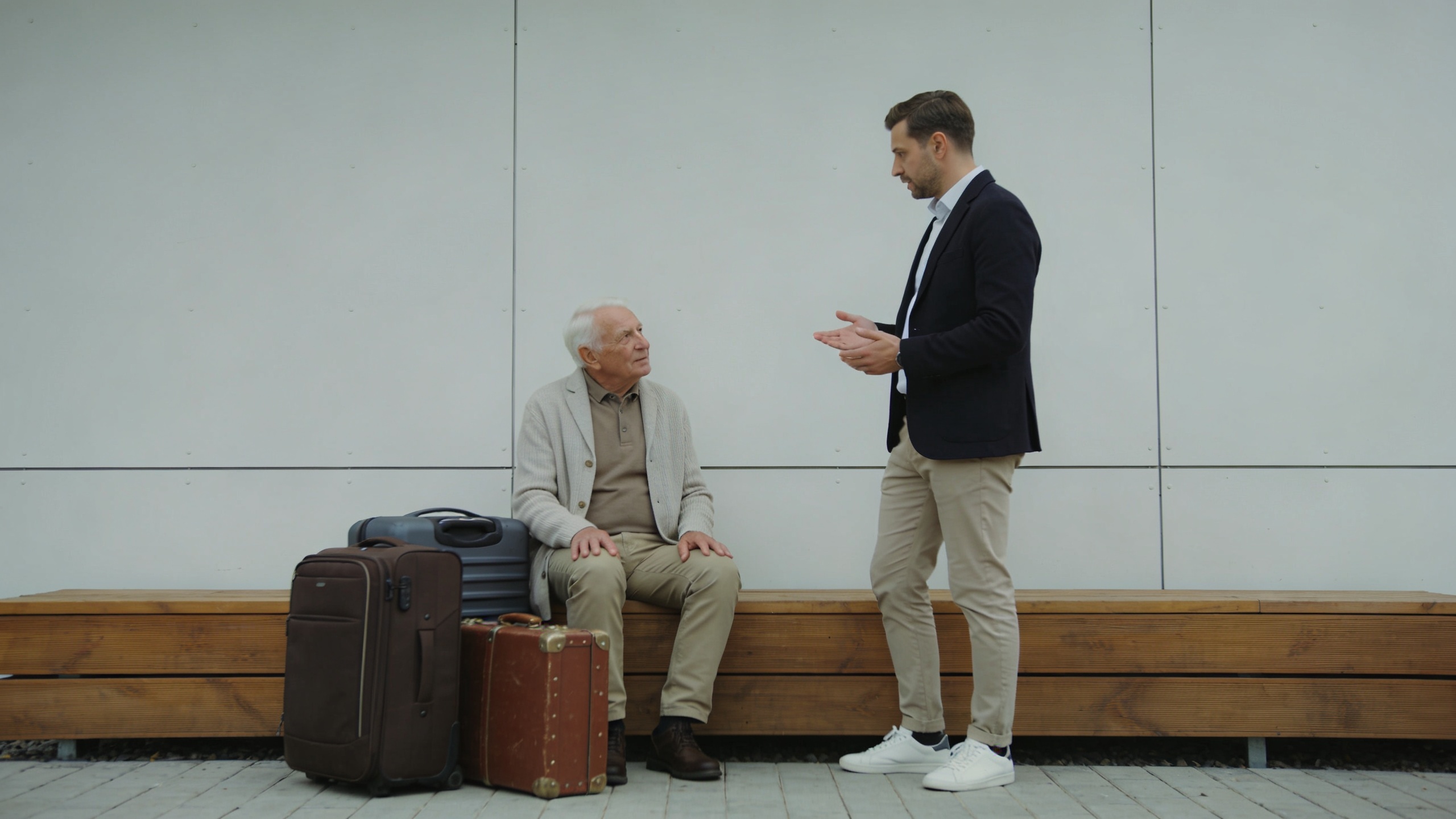 proprietaire discutant avec locataire age assis pres valises